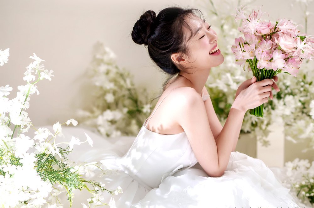 춘천 레브웨딩박람회 스드메 패키지 안내 그림 속 신부 촬영 컷 — 꽃다발을 든 웨딩드레스 화보
